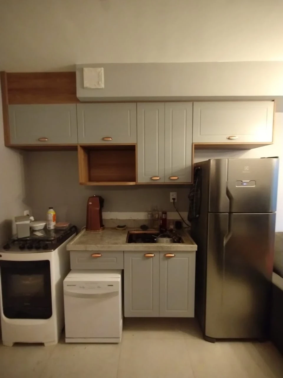 Cozinha Moderna e Funcional: Ambiente com armários em tom azul e detalhes em madeira. Equipamentos em inox e bancada de granito, proporcionando funcionalidade e estilo contemporâneo.